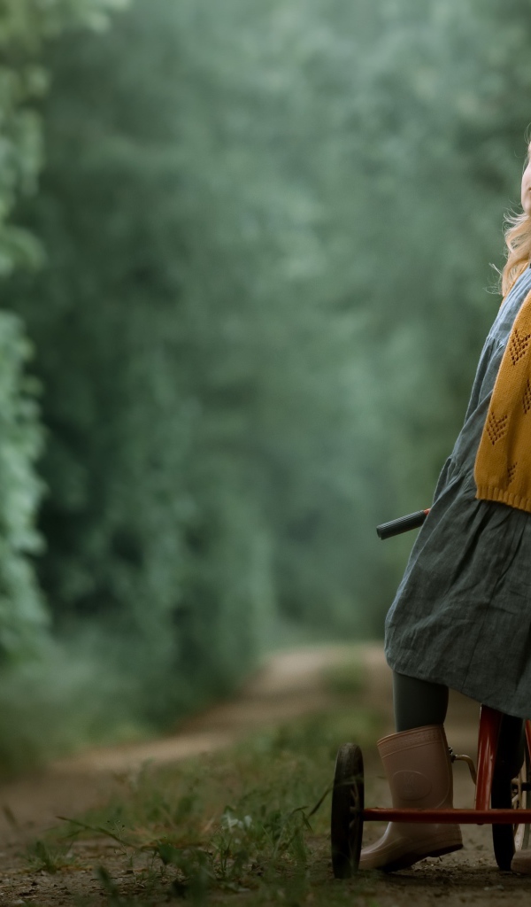 Маленькая девочка на трехколесном велосипеде 