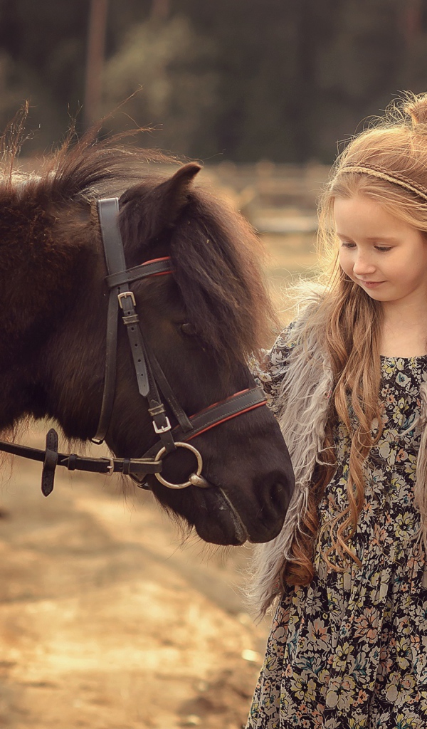 Маленькая девочка с пони на ферме