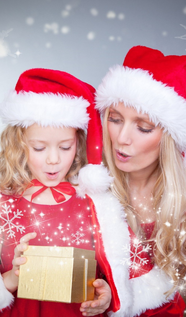 Маленькая девочка с мамой в новогодних костюмах с подарками