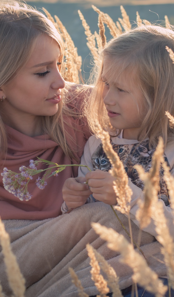 Маленькая девочка с мамой на поле с колосками 