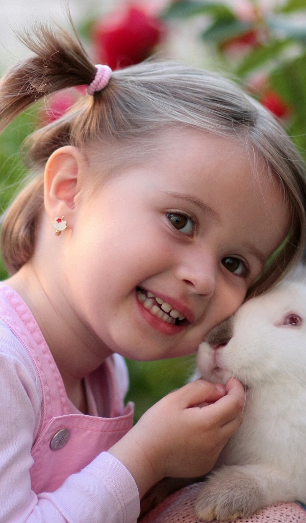 Маленькая улыбающаяся девочка с белым кроликом