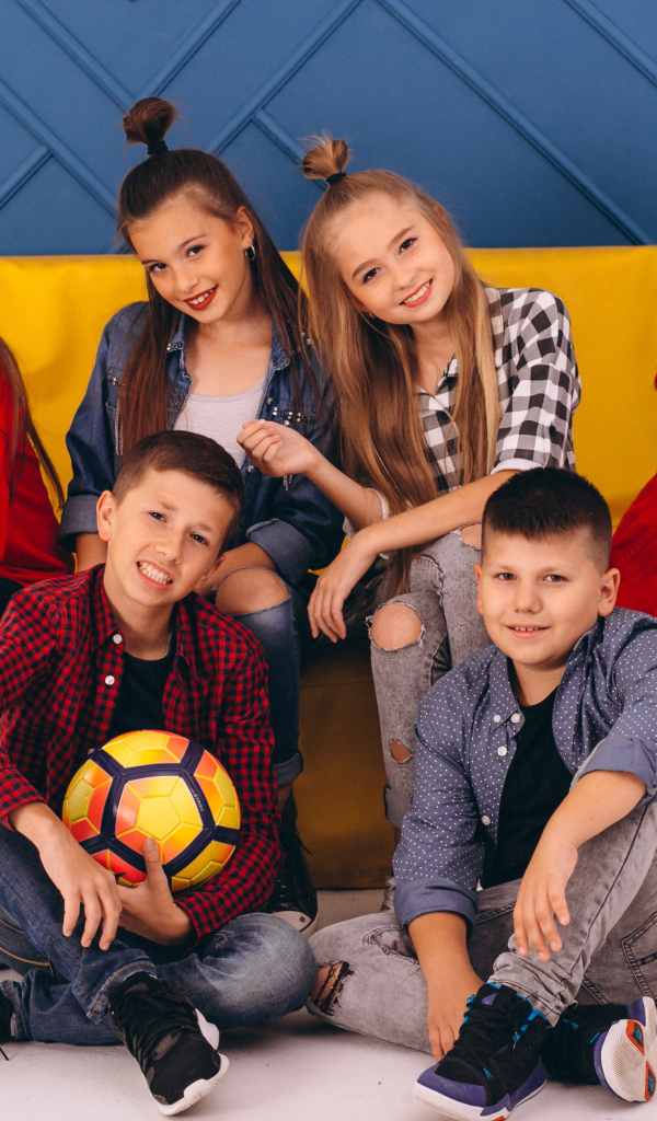 Много модных школьников сидят на диване