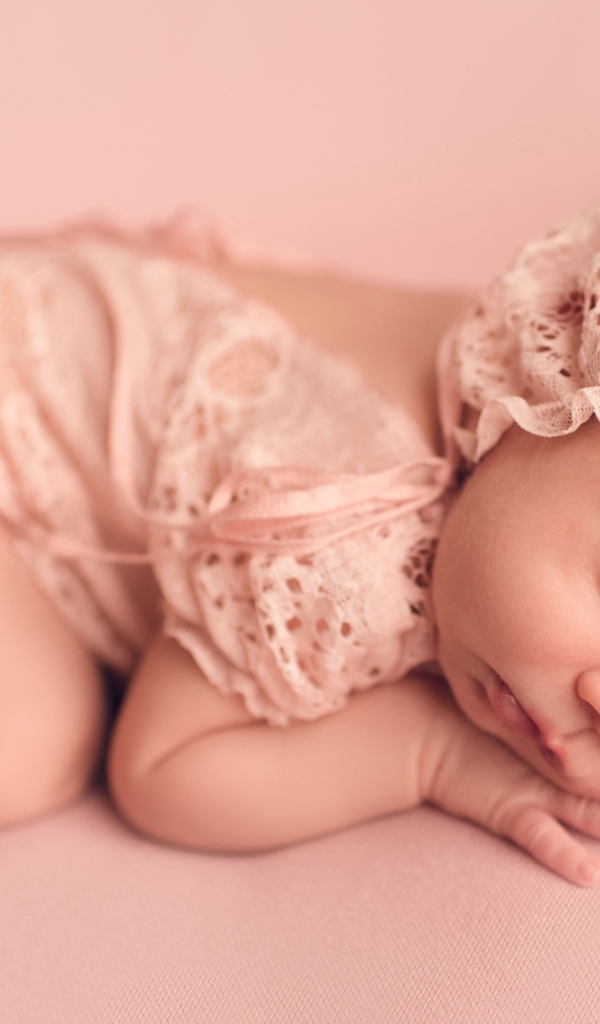 Спящий грудной ребенок в розовом костюме 