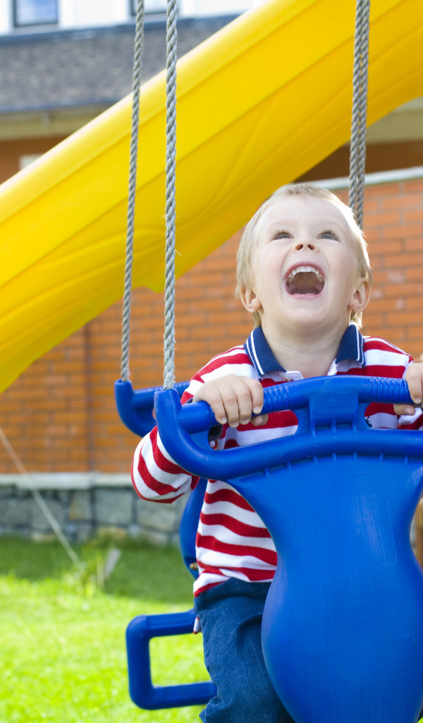 Улыбающийся ребенок на качели 