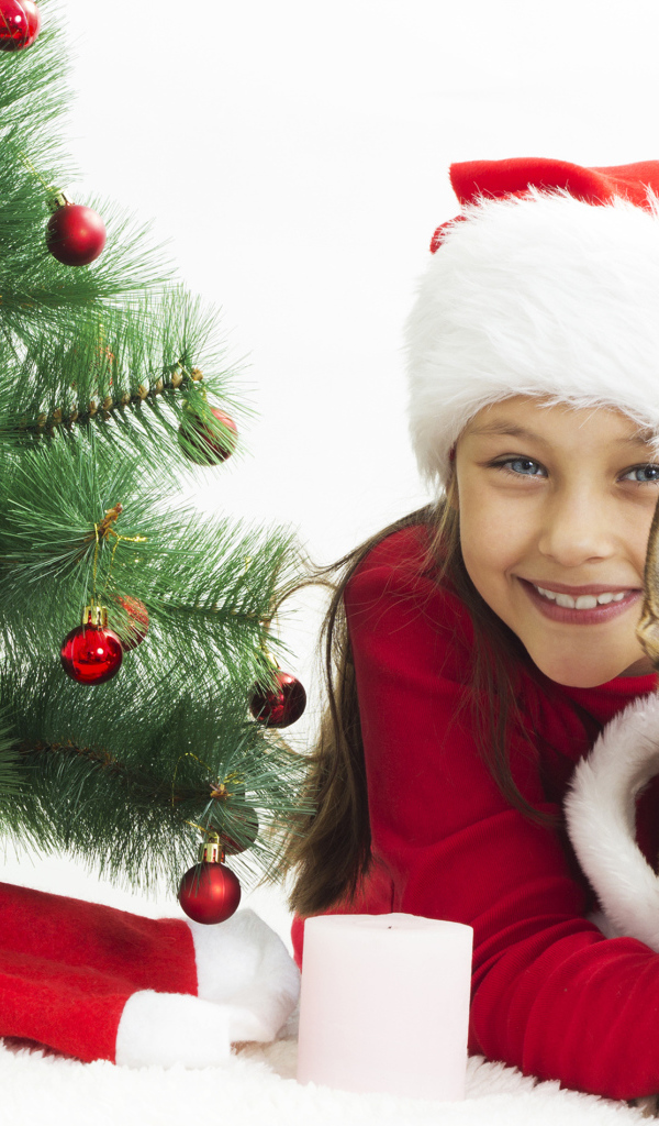 Улыбающаяся девочка с собакой у зеленой елки