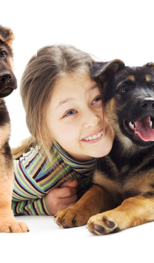 Улыбающаяся девочка с двумя щенками овчарки