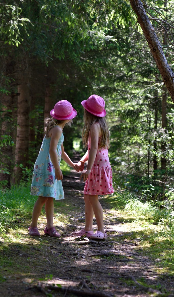 Две маленькие девочки гуляют в лесу