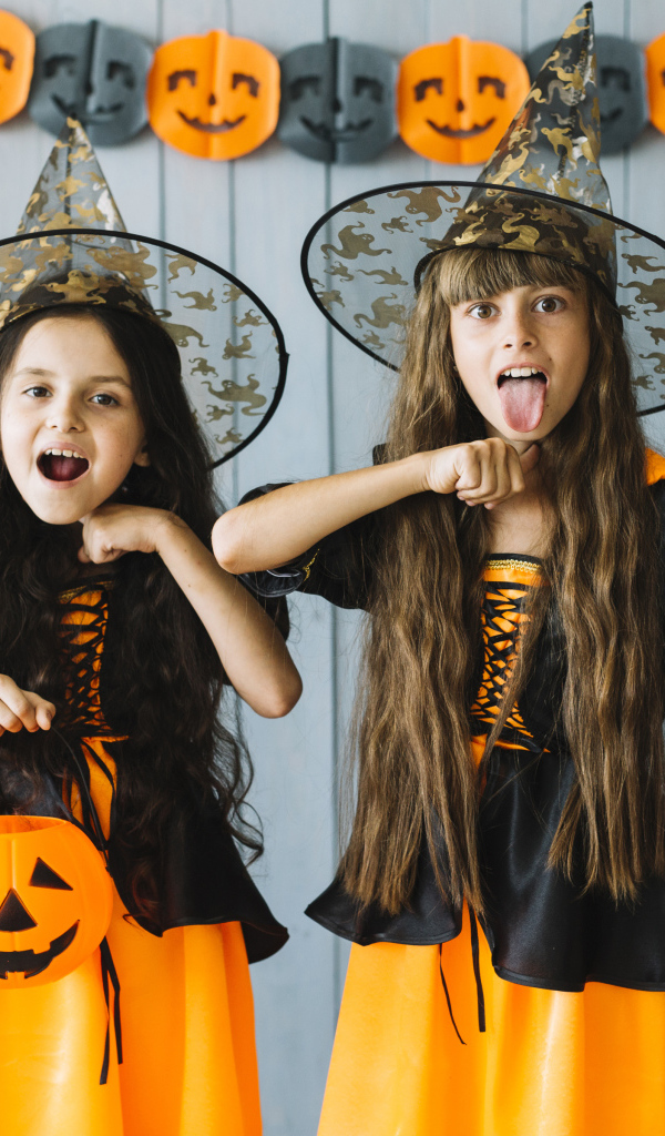 Две маленькие девочки в костюмах ведьмы на Хэллоуин