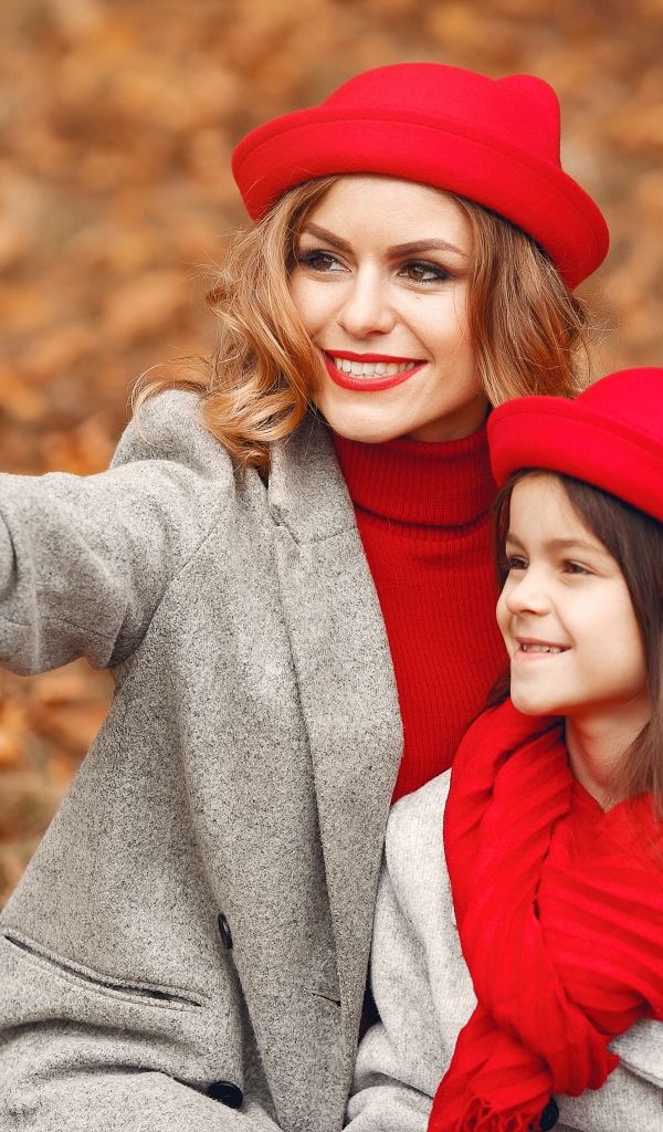 Женщина с маленькой девочкой делают селфи в лесу 