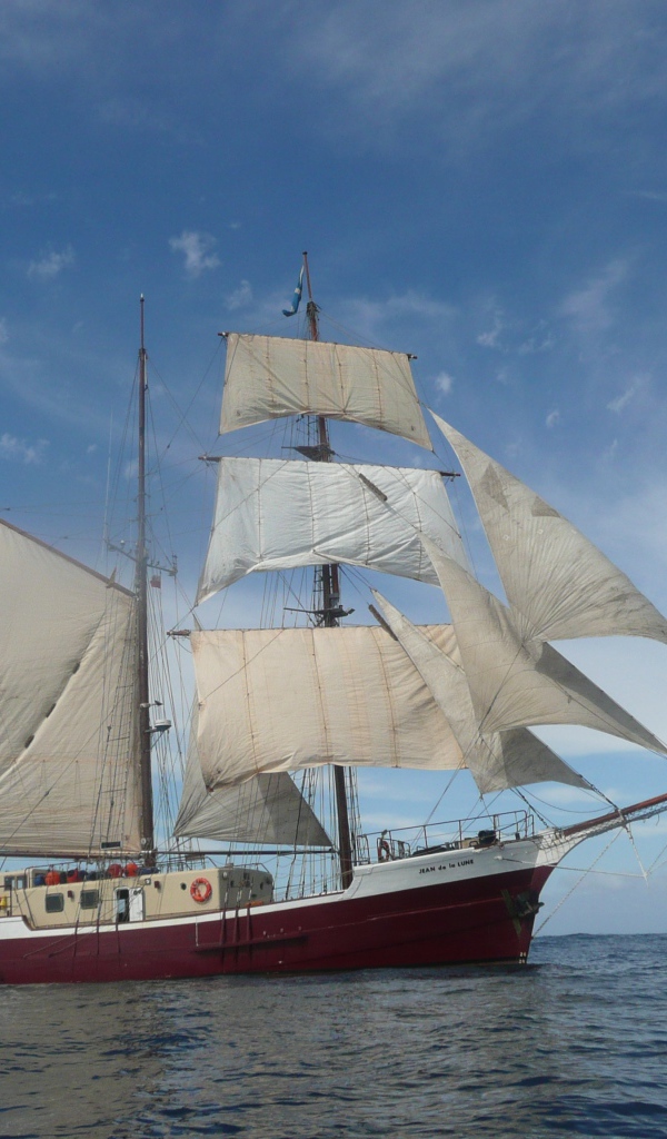 Bigger ship with white sails at sea