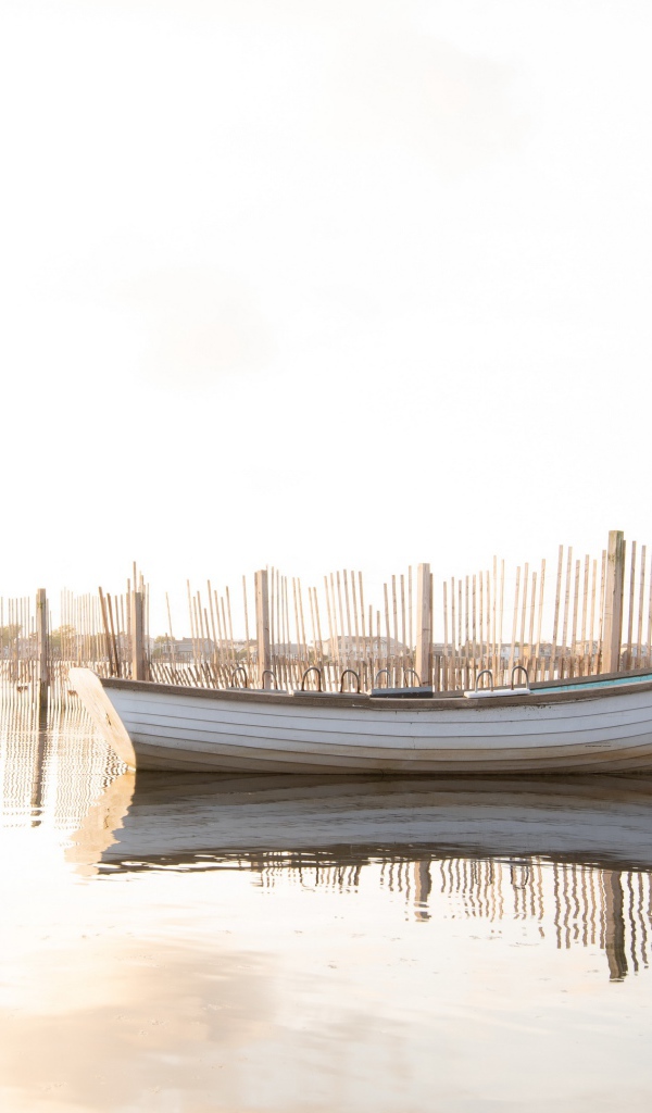 Лодка в воде у ограждения 