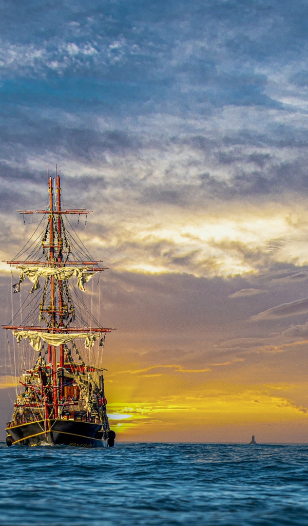 Large pirate ship at sea at sunset