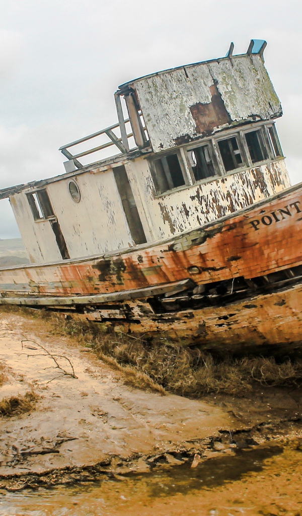 Старая заброшенный рыбацкий баркас на берегу 