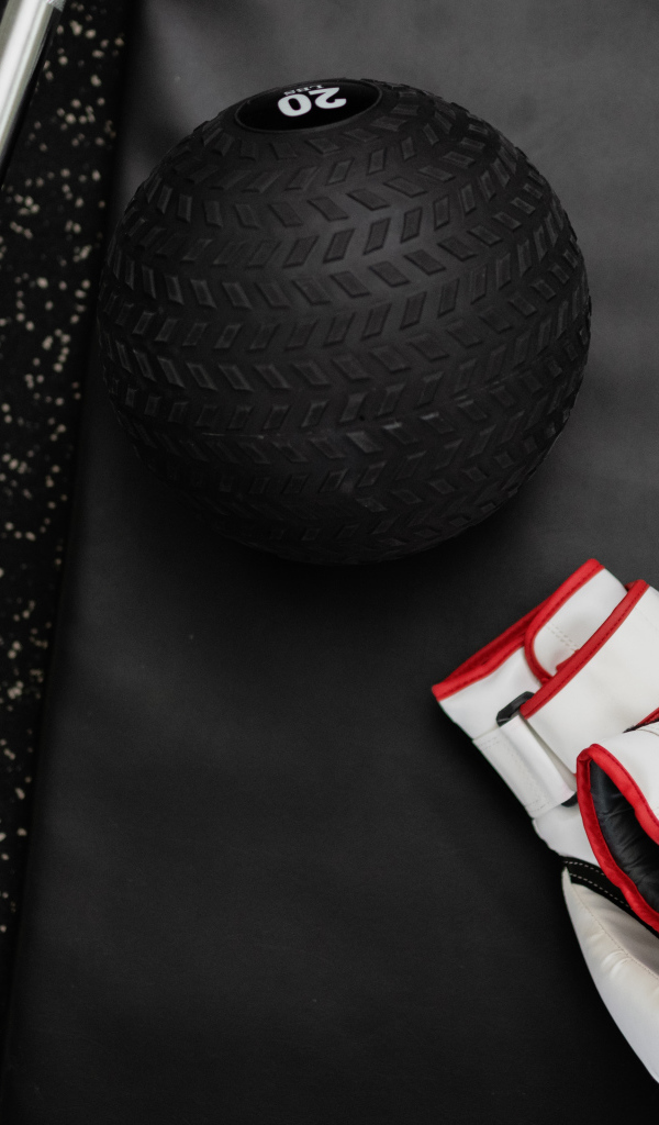 Перчатки и мячик для гольфа лежат в спортзале 