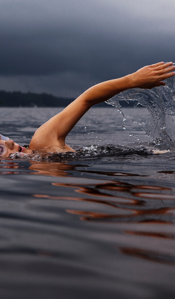 Male swimmer in the lake water