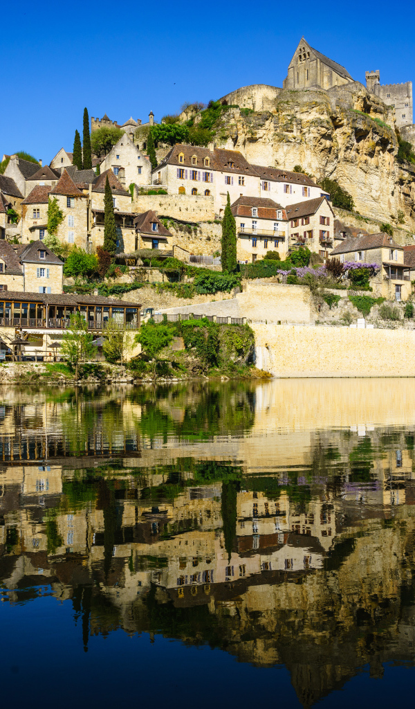 Дома на скале у воды под голубым небом, Франция 