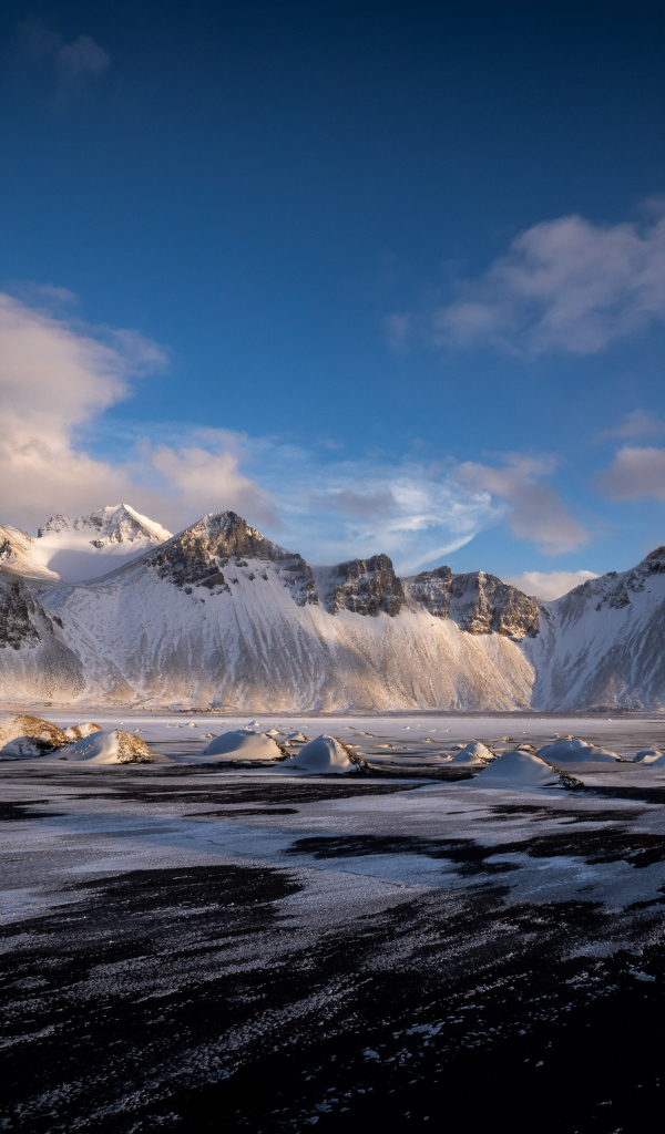 Заледеневшее озеро у заснеженных гор, Исландия