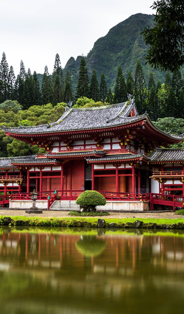 Красное здание храма у воды на фоне горы, Япония
