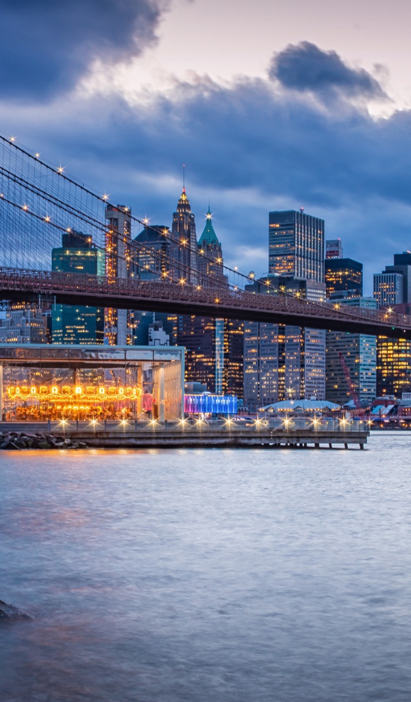 Бруклинский мост через реку на фоне ночного мегаполиса, США