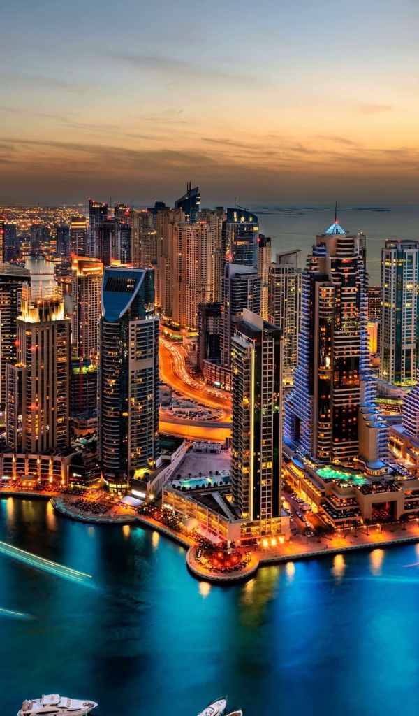 Высокие небоскребы ночного города Дубай у воды 