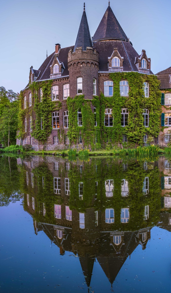 Старинный покрытый зеленью замок Линнеп отражается в воде