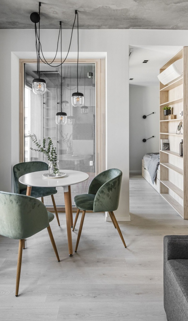 Стол  с креслами стоит у большого окна в квартире 