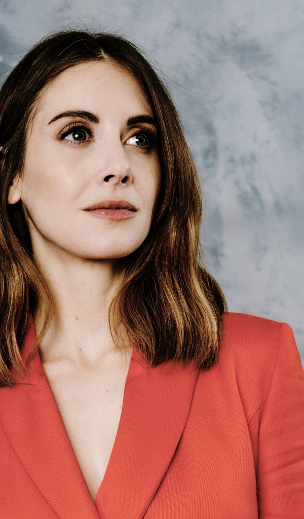 Актриса Элисон Бри в красном пиджаке на сером фоне