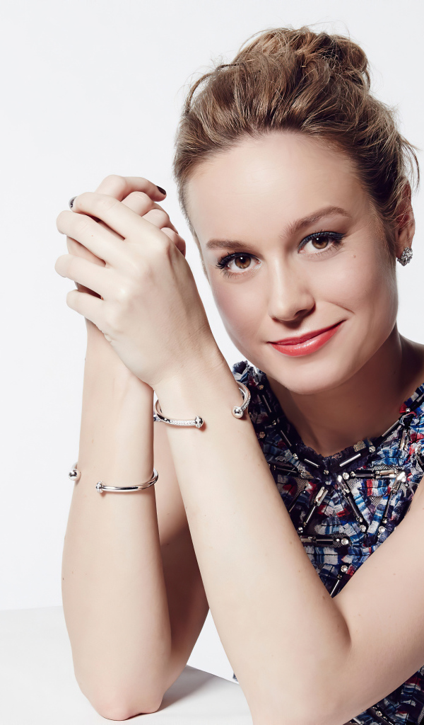 Актриса Бри Ларсон с милой улыбкой на белом фоне