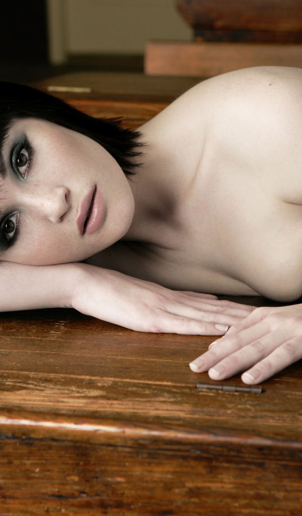 Актриса Джемма Артертон лежит на деревянном столе