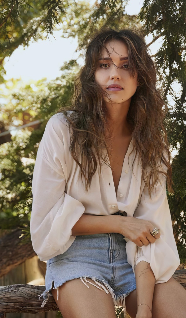 Актриса Джессика Альба сидит на сухом дереве 