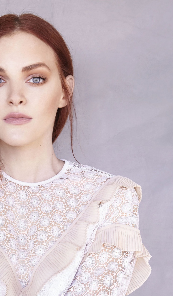 Актриса Мадлен Брюэр в белом платье на фоне стены