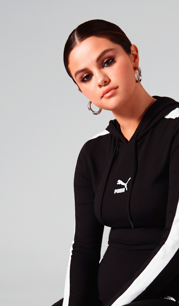 Актриса, модель Селена Гомес в спортивном костюме на сером фоне