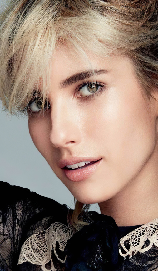 Американская актриса Эмма Робертс в черном наряде на сером фоне