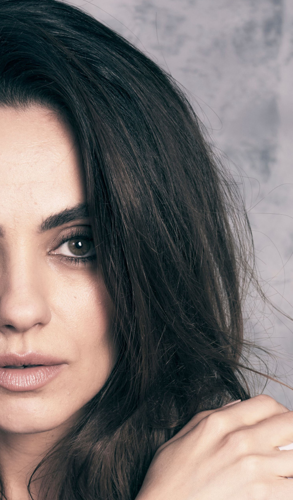 Американская актриса Мила Кунис на сером фоне