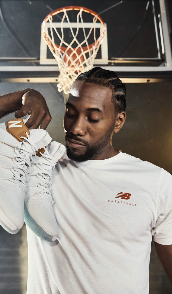 Американский баскетболист Кавай Леонард с кроссовками в руке