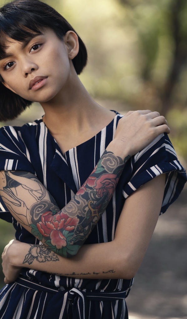 Красивая девушка азиатка с татуировками на руках 