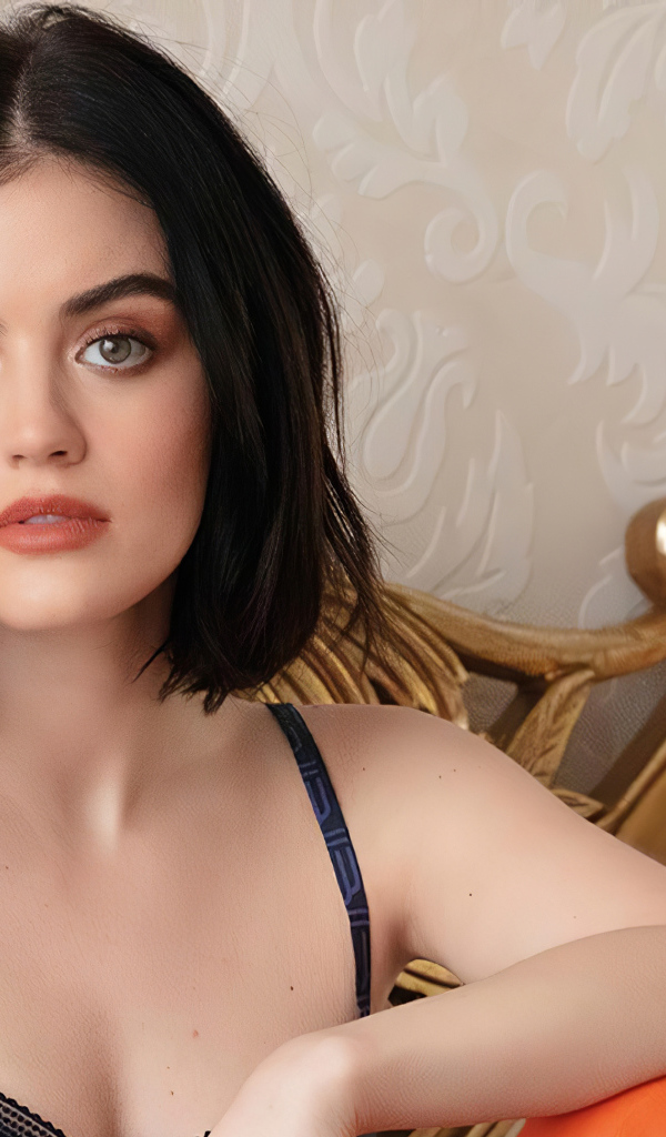 Красивая девушка, актриса Люси Хейл сидит на диване