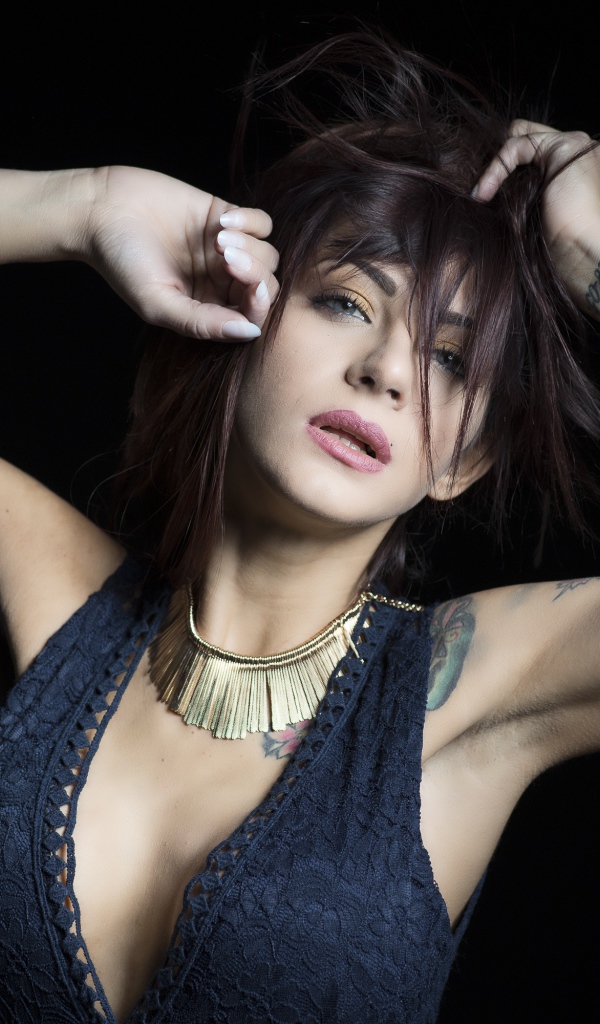 Красивая девушка в черном платье с татуировками на теле 