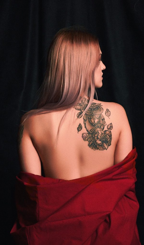 Красивая татуировка совы на спине у молодой девушки