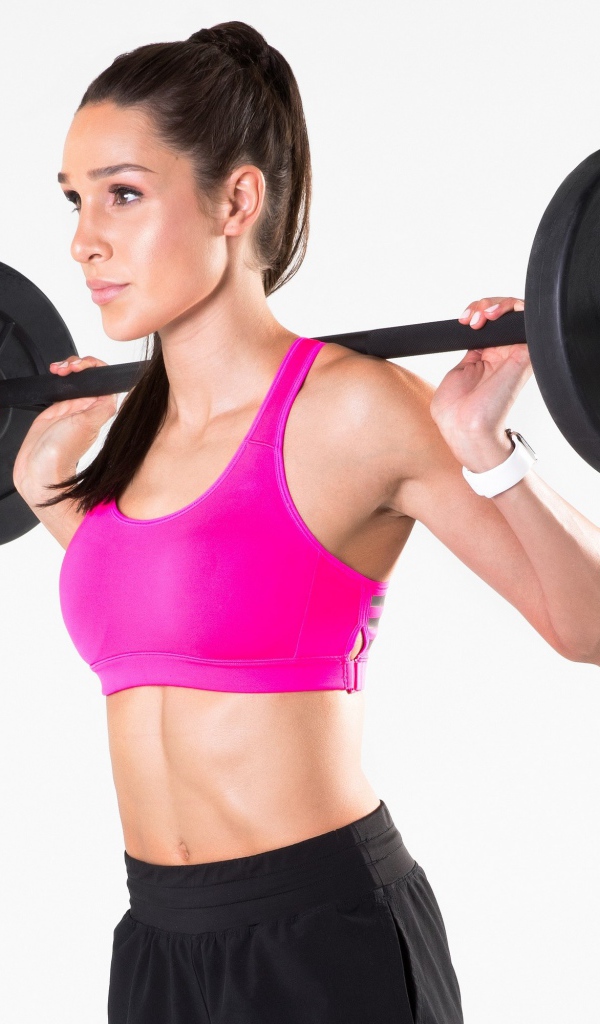 Красивая спортивная девушка со штангой на белом фоне