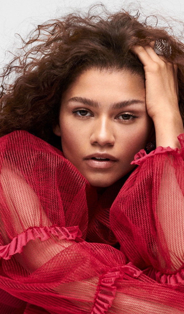 Кареглазая актриса Зендая в красном наряде с рукой в волосах