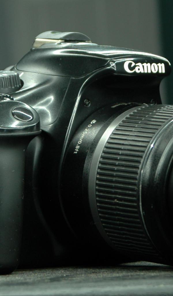 Фотоаппарат Canon 1100D лежит на столе