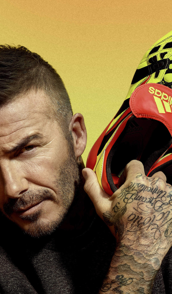 Футболист Дэвид Бекхэм с кедами Адидас в руке