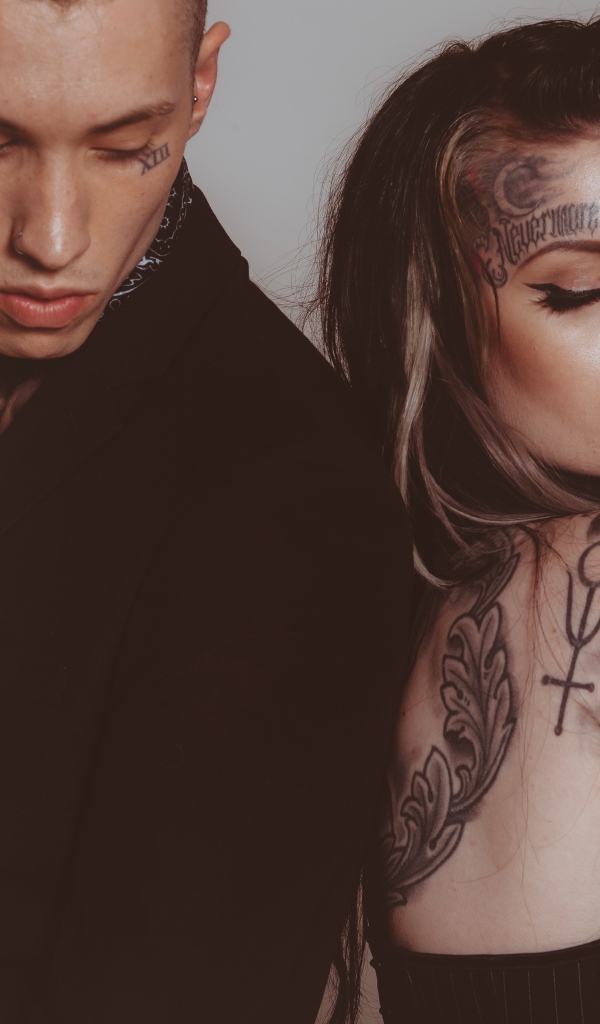 Girl and guy with tattoos on their bodies on a gray background