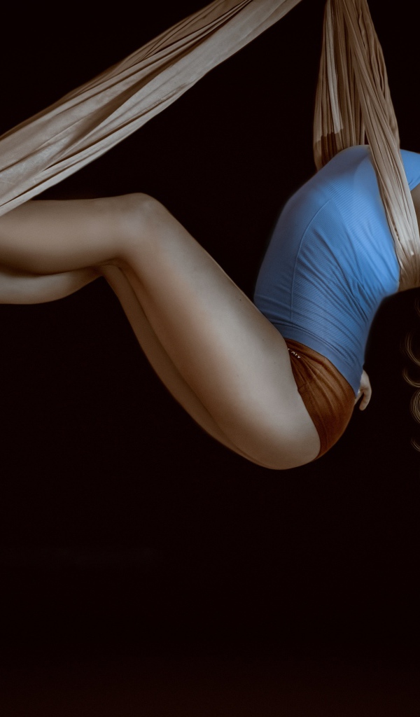 Девушка гимнастка в воздухе на черном фоне