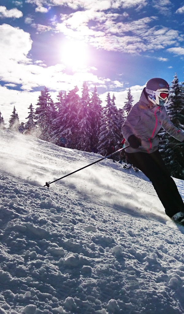 Девушка спускается на лыжах с горы