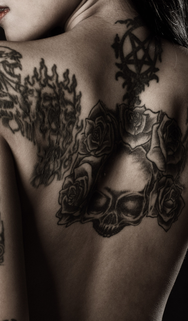 Девушка с татуировками на руках и спине