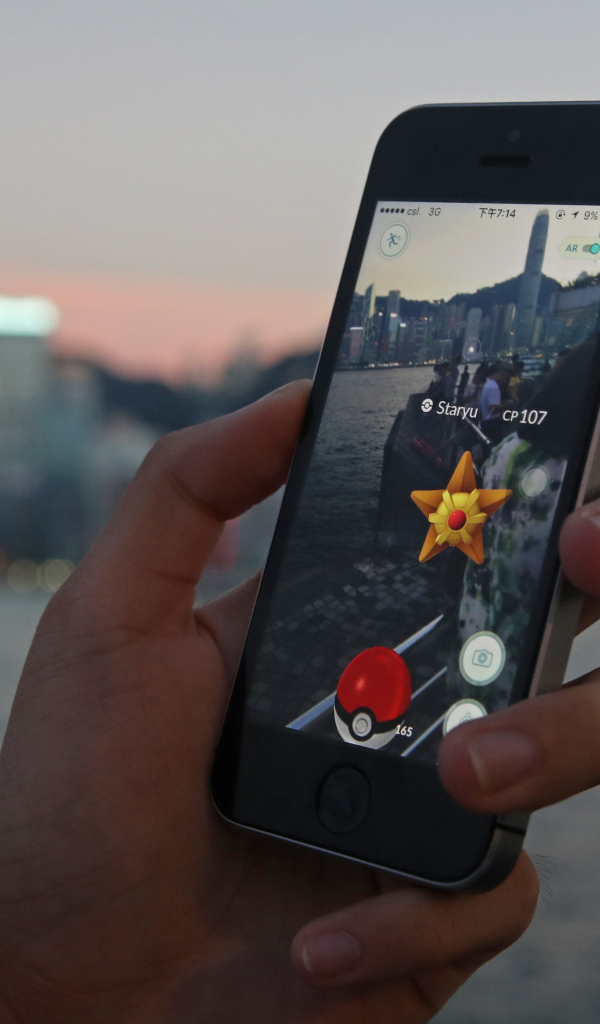 Парень ловит покемонов на смартфоне 