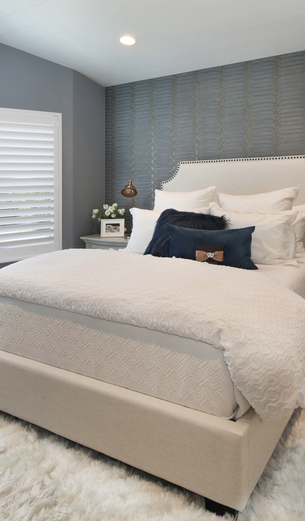 Высокая кровать в спальной комнате в серых тонах