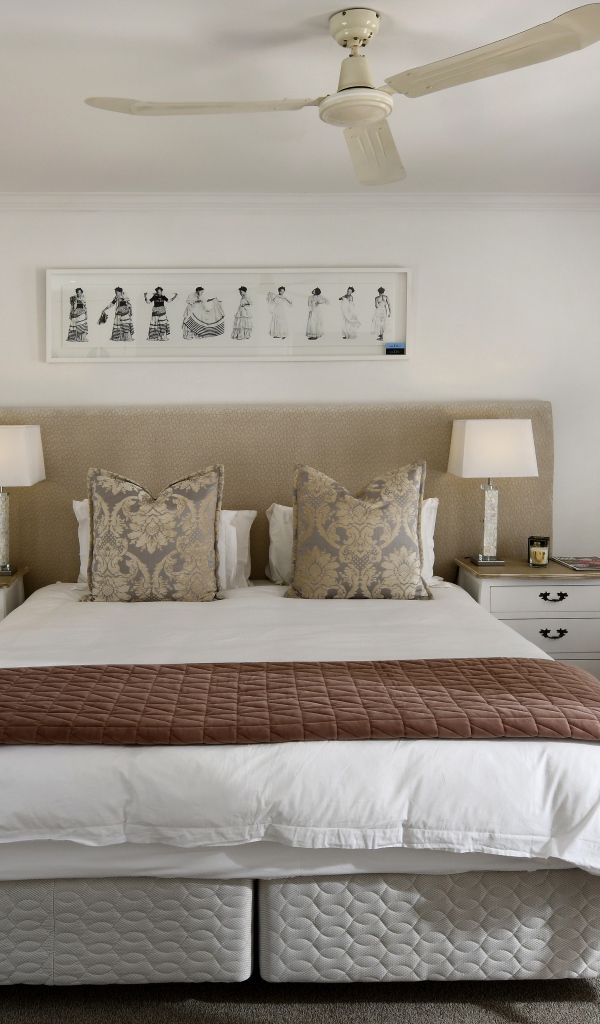 Большая кровать в спальне с вентилятором